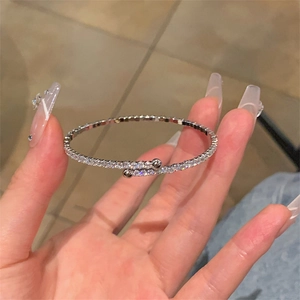 Détail du bracelet demi-rond argenté avec diamants scintillants et perles aux bouts
