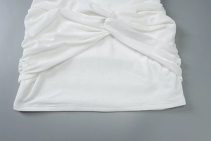 Detail view of white ribbed knit fabric with stylish twist knot and gathered texture