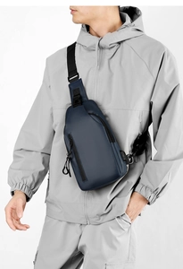 Detail of waterproof dark blue crossbody chest bag showing smooth texture on male model