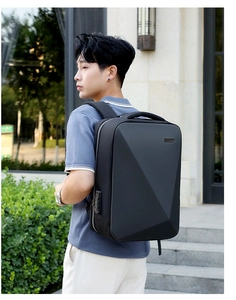 Rear view of man wearing a black hardshell business laptop backpack with geometric design