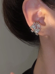 Close-up of zircon flower ear cuff showing silver floral layers on woman's ear