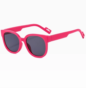 Detail view of pink round frame sunglasses with dark grey UV lenses at 45-degree angle