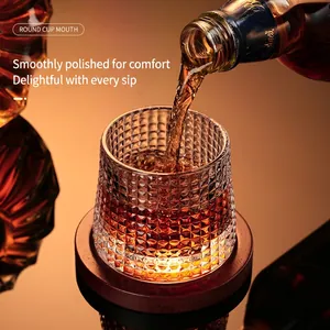 Rotating whiskey glass with diamond texture and red wooden base in warm lighting