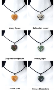 Detailed close-up of six natural heart-shaped gemstone pendants with black leather cords