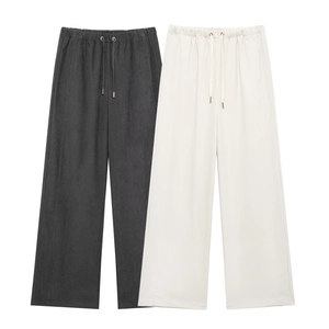 Detail of casual wide-leg trousers featuring elastic waist and metallic tipped drawstrings