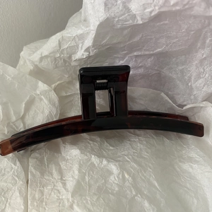 Detailed close-up of dark brown tortoiseshell hair claw clip with glossy resin finish
