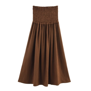 Detailed view of dark brown smocked bodice with pleated fabric and elastic texture
