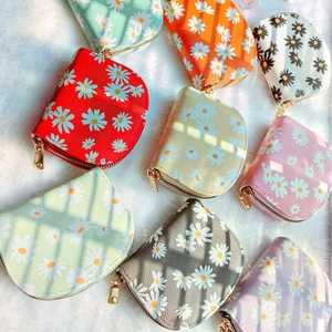 Fresh daisy print PU leather wallets in various colors on white faux fur background