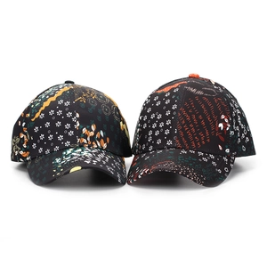 Close-up of ethnic floral print and letter graffiti details on black baseball caps