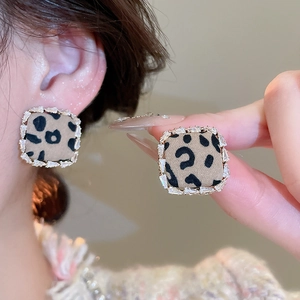 Macro view of leopard print square stud earrings with zircon borders and ear-on display