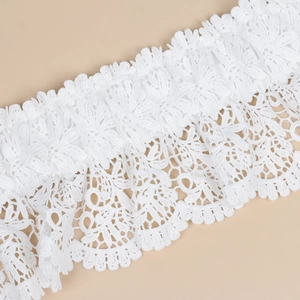 Close-up of white lace corset belt featuring detailed floral embroidery and crochet texture