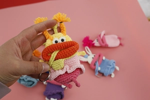 Detailed close-up of handmade crochet sausage mouth key case in colorful knit style
