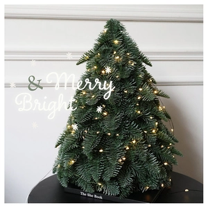 Close-up of a mini artificial Christmas tree with warm LED lights and realistic green needles