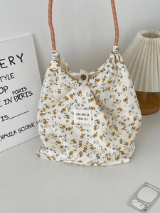 Detail of floral canvas tote bag showing drawstring closure and woven rope handles
