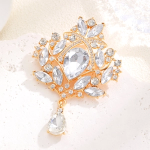 Detailed macro shot of vintage gold alloy brooch with clear pear-shaped crystals
