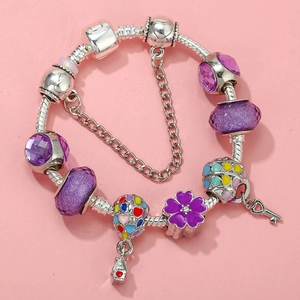 Detail of beaded charm bracelet featuring purple crystals and colorful enamel charms