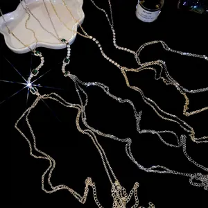 Luxurious gold and silver body chain set with emerald green crystals and tassel accents