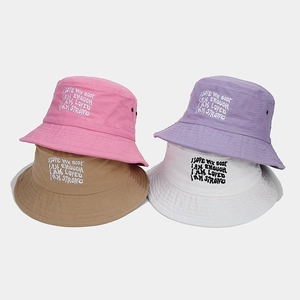 Détail des affirmations brodées sur des bobs colorés pour la protection solaire d'été