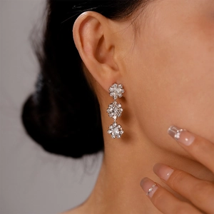 Macro view of silver floral crystal tassel earrings with sparkling three-layer zircon stones