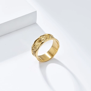 Detailed close-up of golden Eye of Providence relief pattern on a wide stainless steel ring
