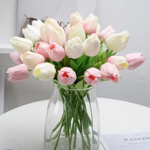 Close-up of artificial pink and white tulips in a clear glass vase for home decor