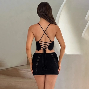 Détail d'un ensemble deux pièces en crochet noir avec haut dos nu lacé et mini-jupe ajourée