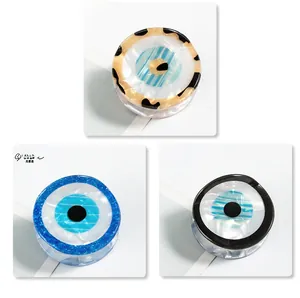 Detailed view of three resin evil eye phone grips with leopard print and blue glitter patterns