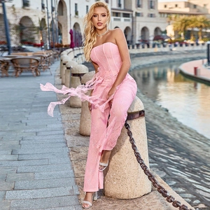Détails de la texture du haut bandeau en dentelle rose et du pantalon évasé