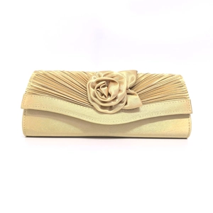 Detail of champagne gold satin evening clutch featuring handmade 3D rose and pleated fabric