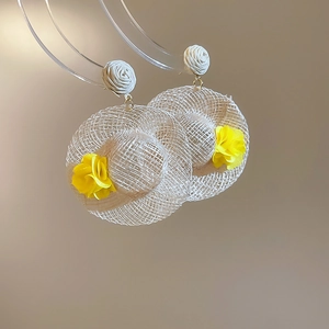 Detail of miniature raffia straw sun hat earrings with yellow flowers and rose studs