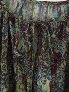 Close-up of metallic paisley chiffon dress with glitter lurex threads and drawstring bow
