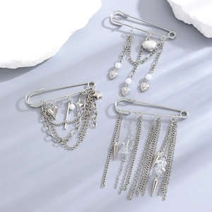 Silver safety pin brooches with heart charms, stars, and layered tassel chains
