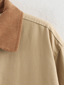 Detail of khaki twill cotton jacket with brown corduroy collar and precise stitching