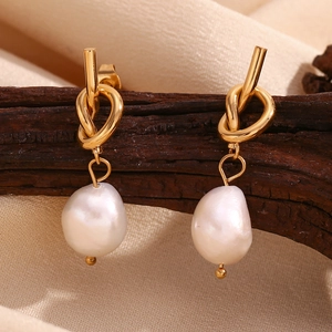 Detail of 18K gold knot stud earrings with hanging white baroque freshwater pearl