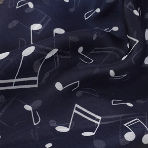 Detail of navy chiffon scarf featuring white musical notes print and soft fabric texture