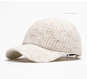 Detail of beige knit baseball cap showing warm wool texture and ribbed brim design