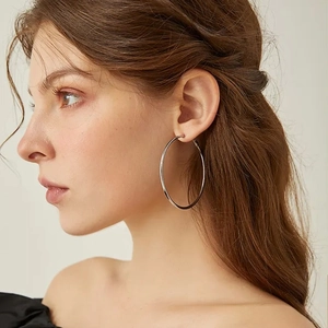 Side view of model wearing minimalist 2mm silver stainless steel large hoop earrings