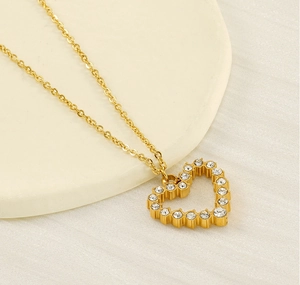 Detail of gold heart pendant necklace featuring sparkling inset cubic zirconia stones