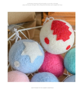 Close-up of colorful wool felt Christmas ornaments with star and tree patterns in a white basket