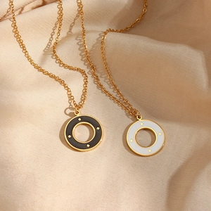 Close-up of gold starburst circular pendants in black and white on silk fabric
