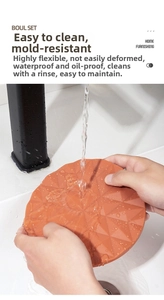 Orange silicone trivet shown under running water to demonstrate easy-to-clean and waterproof feature