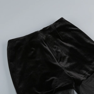 Détail du pantalon en velours noir à taille haute avec fermeture éclair invisible au dos