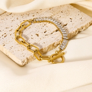 Goldenes Gliederkette-Armband mit Zirkonia und OT-Verschluss auf Marmorhintergrund