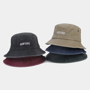 Flat lay of five vintage washed cotton bucket hats with New York embroidery in multiple colors