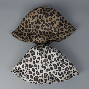 Flat lay detail of leopard print bucket hats in brown and beige thick cotton canvas