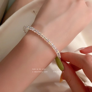 Set bracciale con perle di cristallo cangianti su sfondo di seta beige elegante