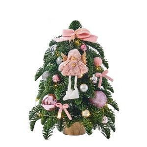 Mini pink Christmas tree with angel, ornaments and wood base on white background