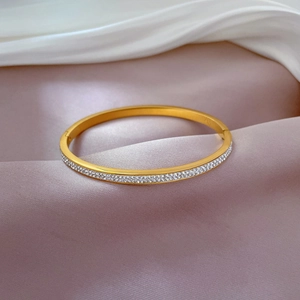 Minimalist gold titanium steel bangle with double row of pavé crystals on satin fabric
