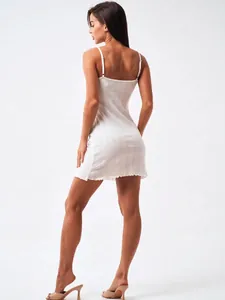 Detail of white knit slip dress showing the ribbed texture and delicate lettuce edge hem