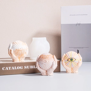 Silicone mold and finished eyeball hand-held plaster ornaments with textured eye detail
